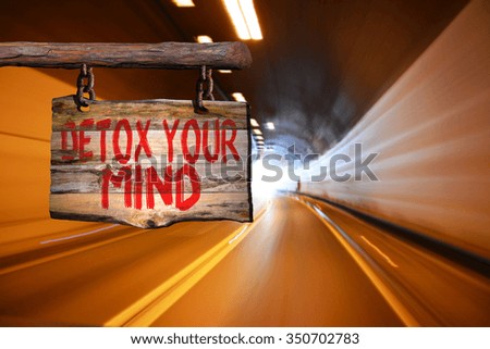Detox your mind motivational phrase sign on old wood with blurred background