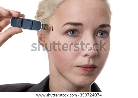 Woman holding a USB memory stick putting it in the side of her head
