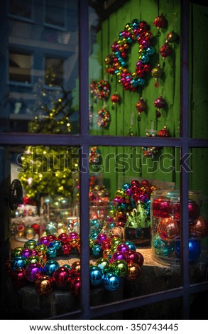 Christmas decoration. Window at night with festive lights and ornaments. Selective focus. Dark toned picture