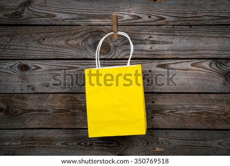 yellow Shopping bag on a wooden background, sale, purchase