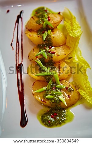 appetizer of grilled celery with greens in a white plate