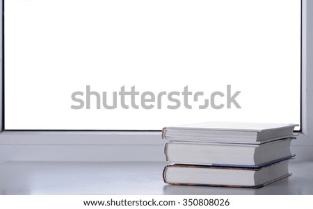 A stack of books on a windowsill with isolated background