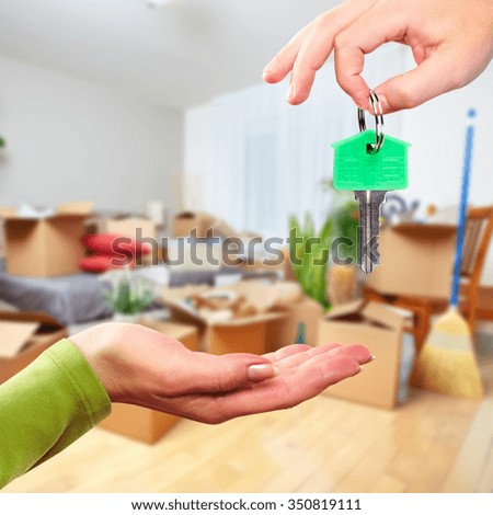 Hand with house key. Real estate and moving background.