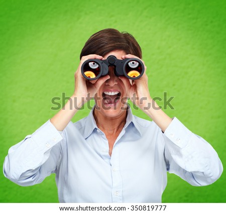 Business woman with binoculars over green background.