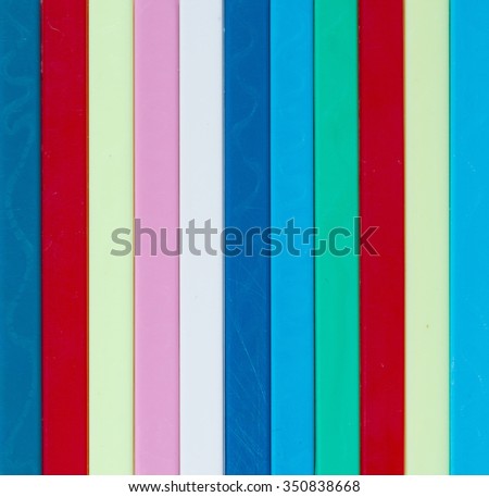 Colorful striped background. Plastique sticks of different colors in the group.