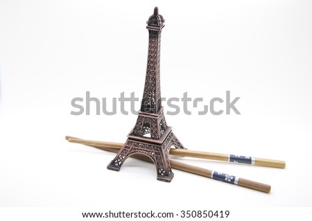 A statue of the Eiffel Tower in with chopsticks isolated over white background