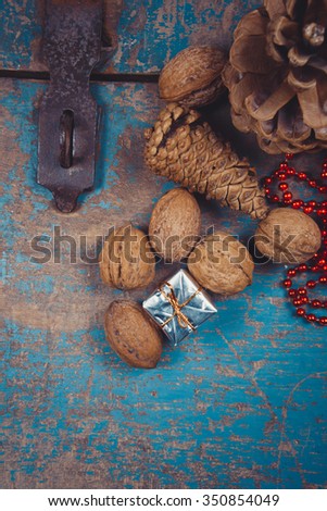  Decoration with gifts, pine cones and walnuts on a wooden background