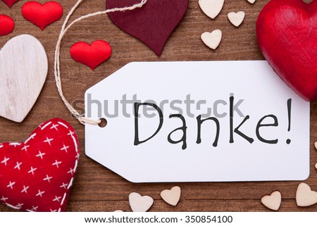 Label With Red Textile Hearts On Wooden Gray Background. German Text Danke Means Thank You. Retro Or Vintage Style. Macro Or Close Up Of One Label