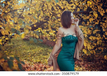 portrait of a beautiful young woman in a autumn park. pictures in warm colors. Model plus