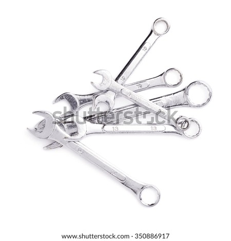 Pile of wrenchs chrome metal spanner instruments isolated over white background