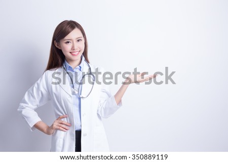 Smiling medical doctor woman with stethoscope show something. asian