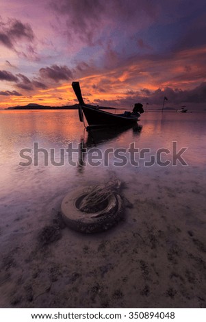 Lonely longtail boat has been anchored during sunrise on Rawai in Phuket