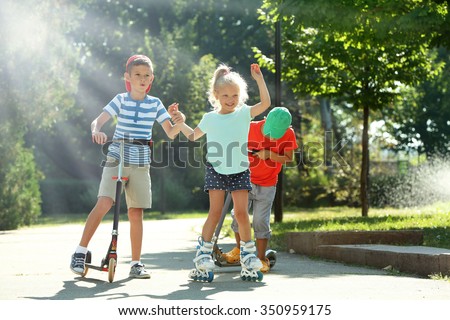 Children riding on scooters and roller skates in park