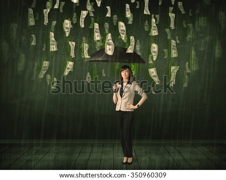 Businesswoman standing with umbrella in dollar bill rain concept on background