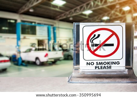 close up of no smoking sign over blurred garage car repair background,abstract background for no smoking concept.