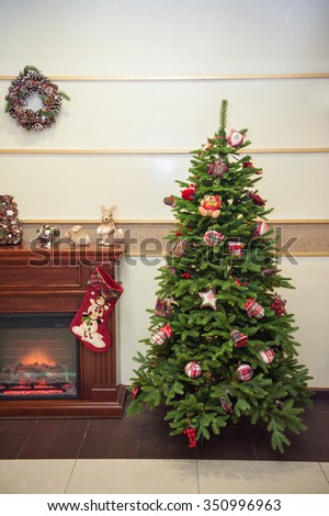 beautiful Christmas tree near a fireplace.