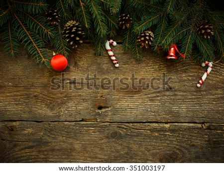 Christmas tree branches with christmas decorations on wooden texture. Winter holidays background