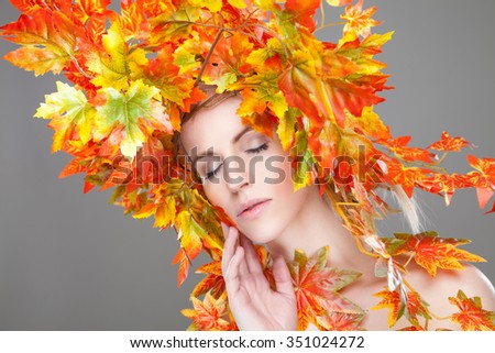 Beautiful young woman wrapped in autumn leafs