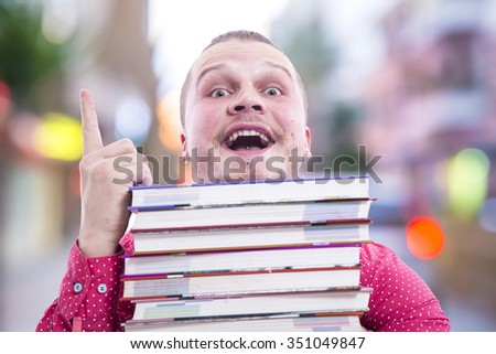 man with a pile of books
