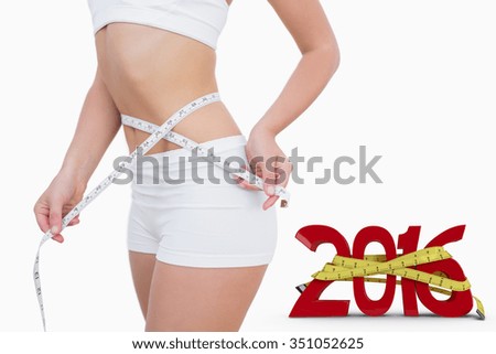 Midsection of woman measuring waist against white background with vignette