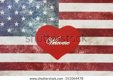 Welcome sign on red heart with rustic American canvas flag blurred in background