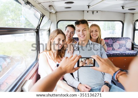 friendship, tourism, travel, technology and people concept - smiling friends with smartphone taking picture