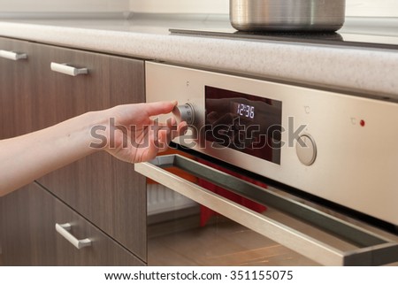 Close Up Of Women Hand Setting cooking mode on oven