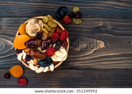 Mix of dried fruits and nuts on a dark wood background with copy space. Top view. Symbols of judaic holiday Tu Bishvat Royalty-Free Stock Photo #351249992