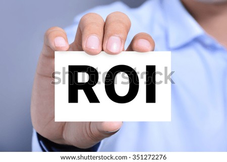 ROI letters (or RETURN ON INVESTMENT) on the card shown by a man