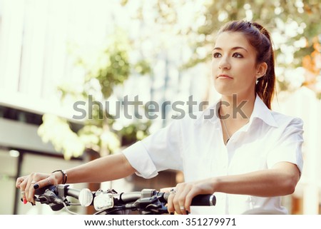 Portrait of happy young female bicyclist riding in city