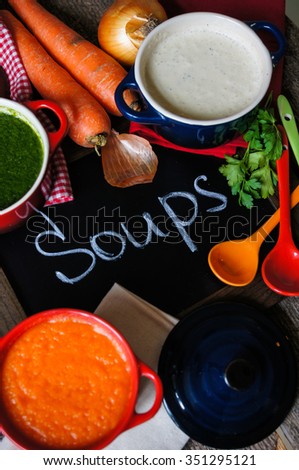 Different kinds of soups - sprinach soup, french onion cream-soup and carrot cream-soup on the table