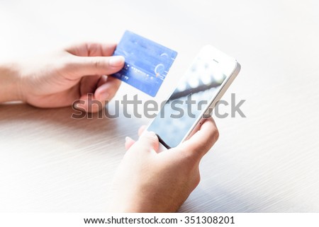 Close-up of man hands with smartphone and credit card as online shopping or online payment concept. Selective and shallow focus.