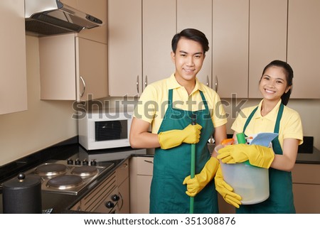 Vietnamese team with cleaning supplies standing in the kitchen Royalty-Free Stock Photo #351308876