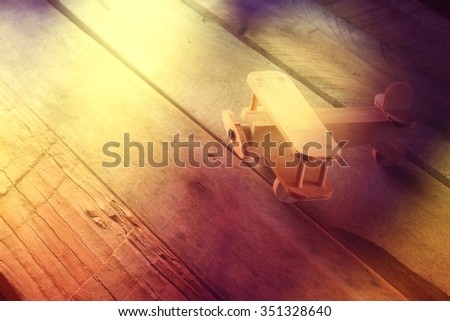 abstract photo of wooden airplane toy over textured wooden background. retro style image. photographed without editing software, using handmade filter
