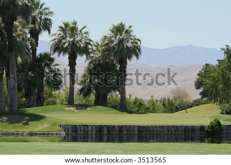 Golf course and a small wooden bridge with mountains in the background