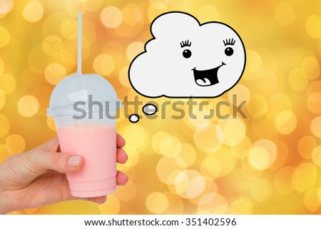 Hand holding healthy juice against glowing background