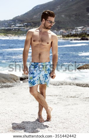 Young man in shorts on holiday, looking down