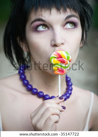 young bizarre girl with colored candy on stick