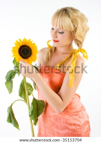 Close-up beautiful fresh young blonde smiling with sunflower with bright make-up in studio shot