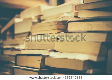 Many old books in a book shop, fair or library. Toned picture