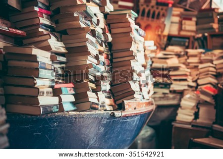 Many old books in a book shop, fair or library. Toned picture
