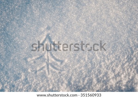 Christmas tree drawing on the first soft snow, toned in blue and yellow colors.