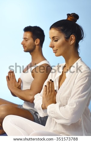 Young couple meditating eyes closed in peace.