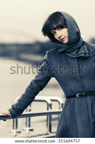 Sad young fashion woman in grey classic coat outdoor