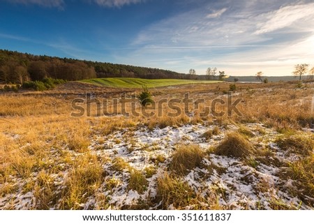 Early winter or late autumnal landscape of field at good weather. Fields with little snow. 