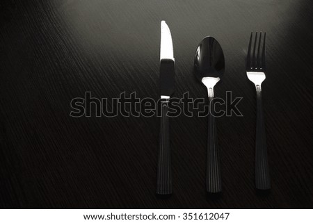 cutlery on a black table dark tone