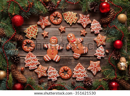 Gingerbread man and woman couple, fir tree, stars, christmas cookies composition with xmas tree decoration on vintage wooden table background. Homemade traditional new year dessert food recipe.