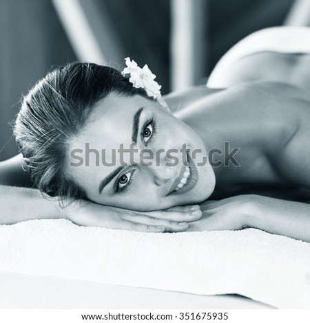Portrait of a beautiful young woman lying on massage at spa center