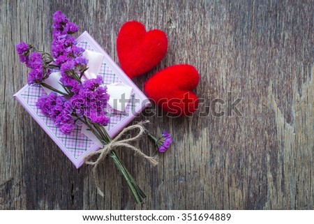 Red heart with gift box and purple flower on wooden background, Valentine concept