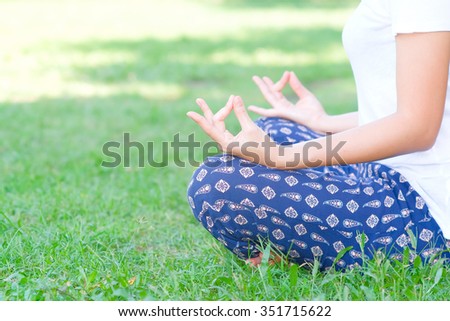 Beautiful Asian girl meditating in park
